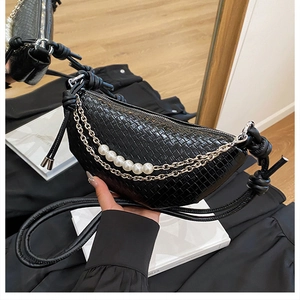 Détail du sac demi-lune noir en faux cuir croco avec perles et chaîne argentée élégante