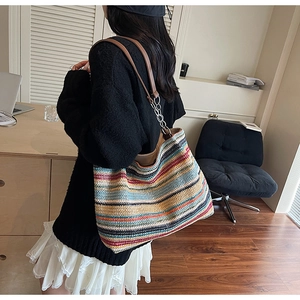 Dettaglio borsa shopper a righe colorate con tracolla in pelle e catena metallica