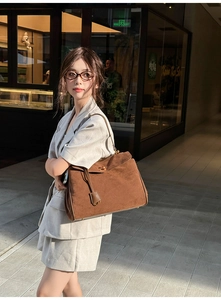 Nahaufnahme der braunen Wildledertasche mit Vintage-Metalldrehverschluss und Details