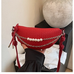 Détail du sac croissant tressé rouge avec chaîne en perles et bandoulière nouée
