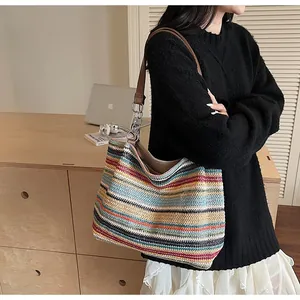 Dettaglio borsa tote in maglia a righe colorate con tracolla in pelle e catena in metallo
