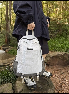 Detail of outdoor backpack with side drawstring pockets and durable reinforced base