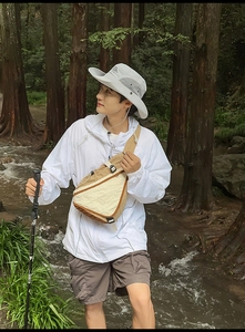 Close-up of waterproof crossbody bag with adjustable strap in outdoor forest setting