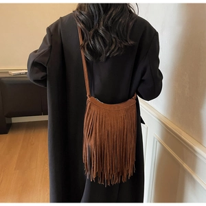 Brown suede tassel crossbody bag worn by model showing vintage fringe and fringe drape