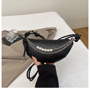 Détail du sac demi-lune tressé noir avec breloques en perles et chaîne en métal