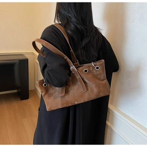 Detailed view of brown retro shoulder bag with silver eyelets on vintage leather texture