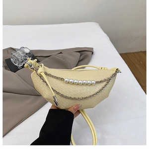 Dettaglio della borsa a mezzaluna giallo chiaro con trama a scacchi e catena di perle
