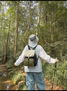 Outdoor waterproof nylon backpack showing color-block design and buckle detail in forest setting