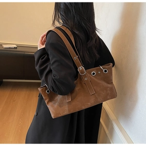 Detailed back view of vintage brown leather tote bag with stylish metal eyelet accents