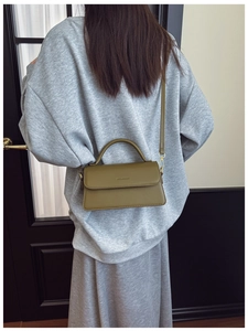 Olive green leather bag shown on model, minimalist shoulder and crossbody style