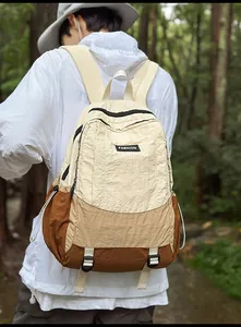 Macro shot of lightweight beige and brown nylon outdoor backpack in a forest setting