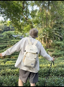Detail of multi-pocket outdoor backpack with adjustable straps on a hiking model