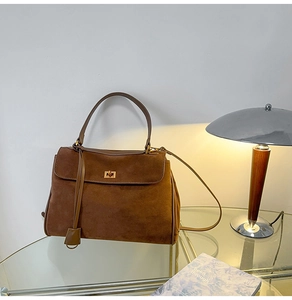 Detail der braunen Vintage-Wildledertasche mit goldenem Verschluss und Glattleder-Besatz