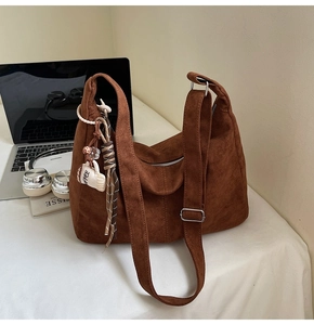 Brown faux suede hobo bag detail with coffee cup charm and striped silk scarf