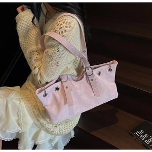 Detail of light pink suede tote bag featuring silver eyelets and leather strap on stairs