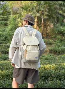Detail of water-resistant wrinkled fabric and side buckle on the cream outdoor backpack