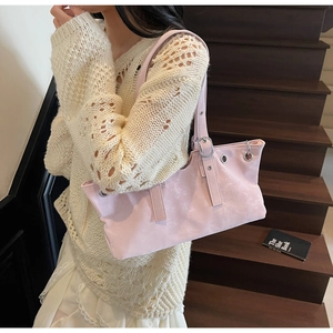 Detail view of pink suede tote bag with metal eyelets and adjustable buckle shoulder strap