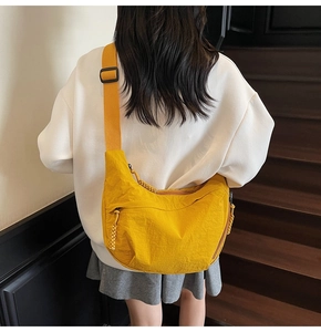 Dettaglio della borsa a mezzaluna in nylon giallo brillante con ampia tracolla regolabile