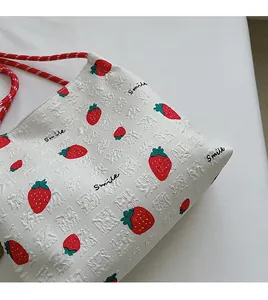 Close-up of textured fabric showing strawberry prints and braided rope strap details