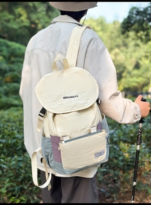 Close-up of lightweight hiking backpack with buckle flap and textured beige fabric