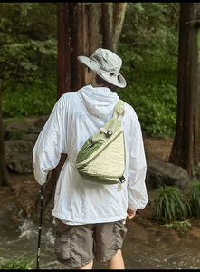 Detail of army green nylon crossbody chest bag showing buckle strap and texture