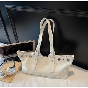 Detailed macro view of white tote bag with silver eyelets and smooth faux leather texture