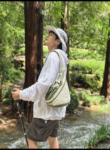 Outdoor crossbody bag in beige and green fabric shown during a forest hiking session