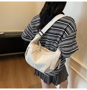 Dettaglio della borsa a tracolla in nylon beige con tracolla regolabile e tiralampo intrecciato
