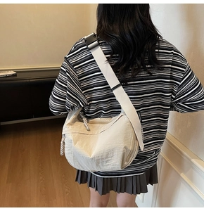 Dettaglio di una borsa a tracolla beige a mezzaluna con cerniera in corda intrecciata