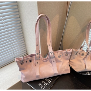 Pink faux leather hobo bag with wavy edges, metal eyelets and decorative buckles