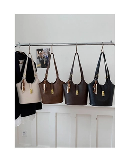 Detail view of four vintage faux leather bucket bags in cream, brown, and black colors
