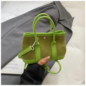 Detail view of suede and leather mix crossbody tote bag in shades of olive green