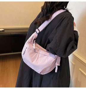 Dettaglio della borsa a tracolla viola chiaro con cerniera in corda bianca intrecciata