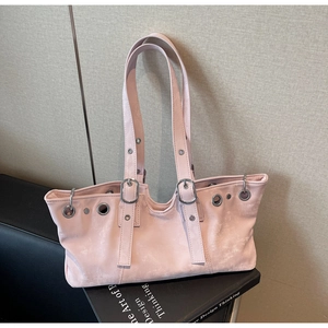 Detail of pink suede tote bag featuring silver metal grommets and retro buckle straps