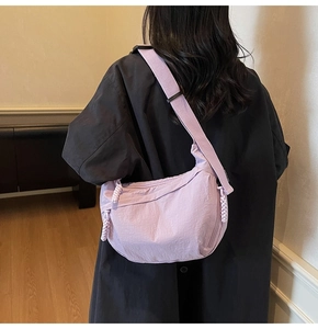 Vista dettagliata della borsa a tracolla a mezzaluna in nylon lilla indossata