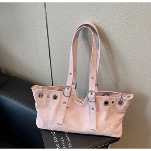 Close-up of pink suede tote bag with metal eyelets and wavy top edge design
