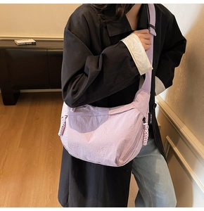 Dettaglio della borsa a mezzaluna in nylon lavanda con tirante e etichetta laterale
