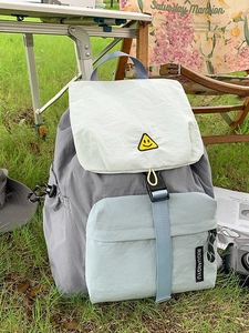 Outdoor color-block nylon backpack with smiley patch in a casual camping setting