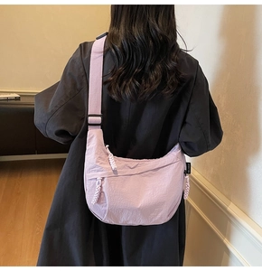 Dettaglio posteriore di una borsa a tracolla a mezzaluna lavanda indossata da una modella