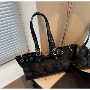 Detailed view of black PU leather tote bag with silver eyelets and punk style buckled straps