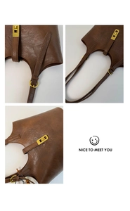 Detailed view of the dark brown leather bucket bag featuring gold buckle and fine texture