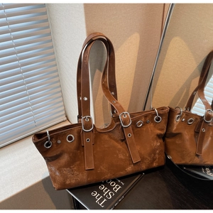 Detail of distressed brown leather texture with silver eyelets and buckle on tote bag