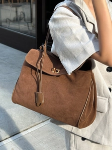 Vintage braune Wildleder-Tragetasche mit goldener Schnalle an einem Model