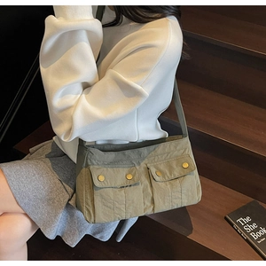 Detailed macro view of olive green nylon bag with functional front metal buckle pockets