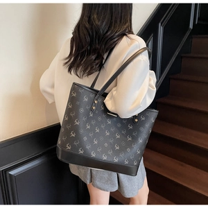 Rückansicht eines grau bedruckten Leder-Tote-Bag an der Schulter eines Modells
