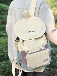 Outdoor nylon backpack in off-white and purple with buckle closure and matching mini pouch