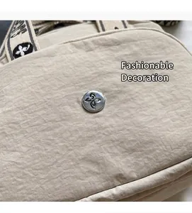 Detail aus beigem Stoff mit Knitteroptik, silberner Schnalle und Jacquard-Gurt