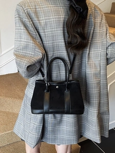 Women's casual black tote bag with dual handles and adjustable strap in a stylish scene