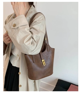 Detail of vintage dark brown tote bag with gold twist lock and wrinkled leather texture