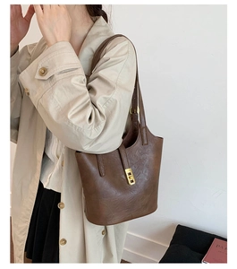 Detail of vintage brown leather tote bag featuring a polished gold metallic buckle closure